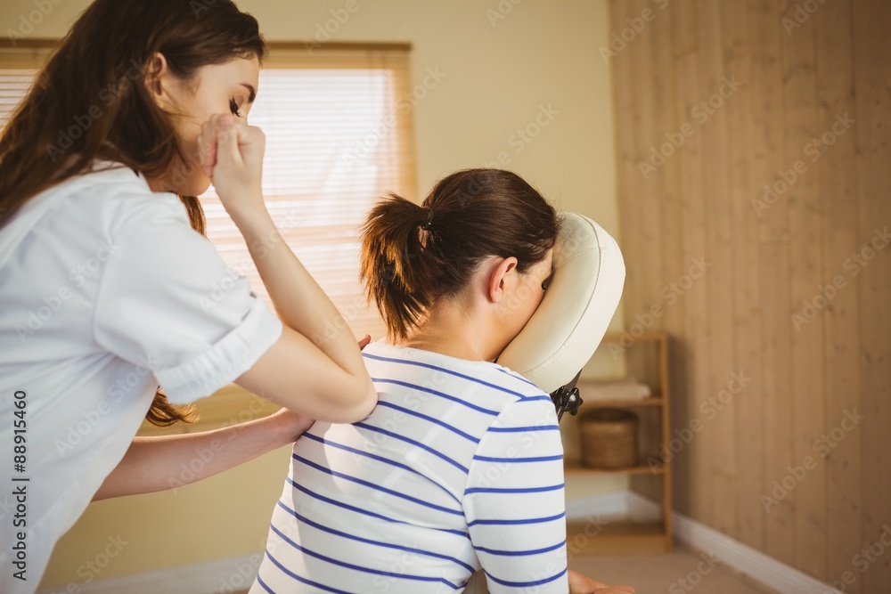 Young woman getting massage in chair Young woman getting massage in chair