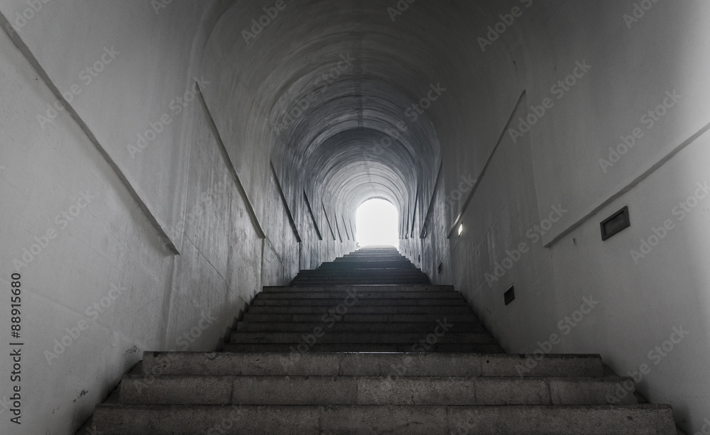 Light at the end of tunnel with ascending stairs