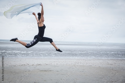 Fit girl leaping with scarf 