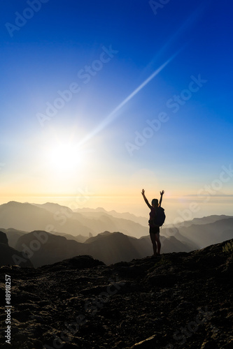 Woman hiking success silhouette in mountains sunset