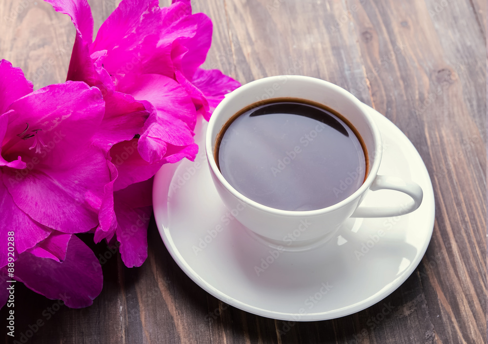 Cup of black coffee and pink flowers Cup of black coffee and pink flowers
