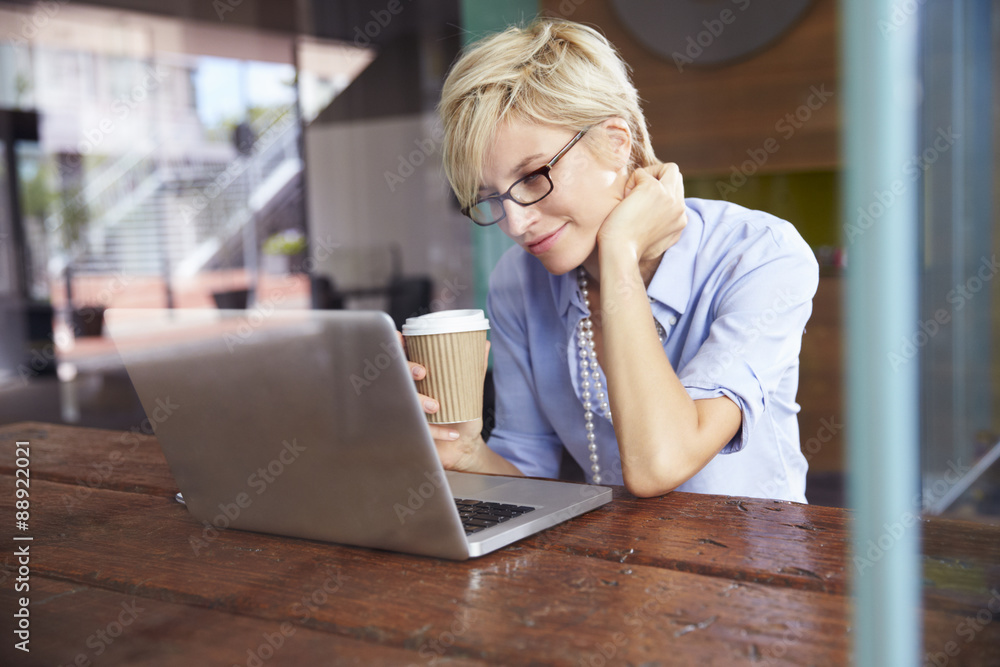 Businesswoman Working On Laptop In Coffee Shop Businesswoman Working On Laptop In Coffee Shop