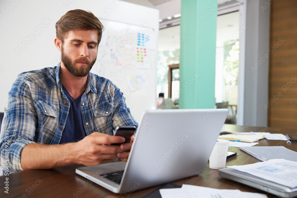 Businessman Using Phone Working On Laptop In Office Businessman Using Phone Working On Laptop In Office