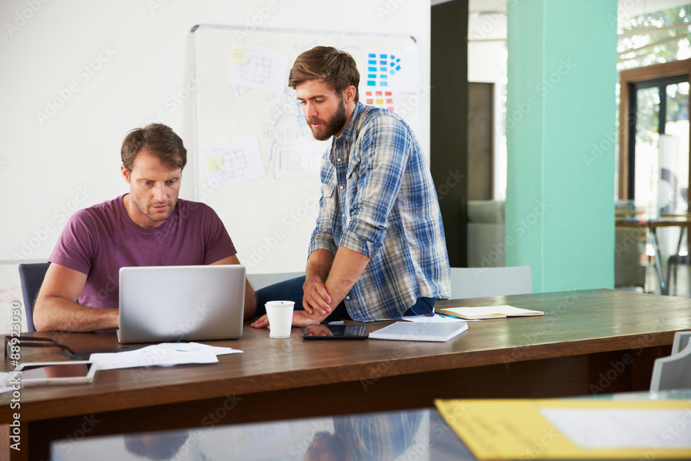 Two Businessmen Working On Laptop In Office Together Two Businessmen Working On Laptop In Office Together