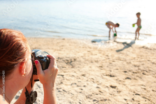Mother making photo of children at the beach. © Vitalinka