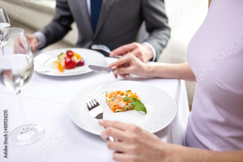 close up of couple eating appetizers at restaurant