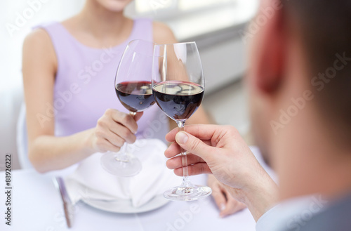 young couple with glasses of wine at restaurant