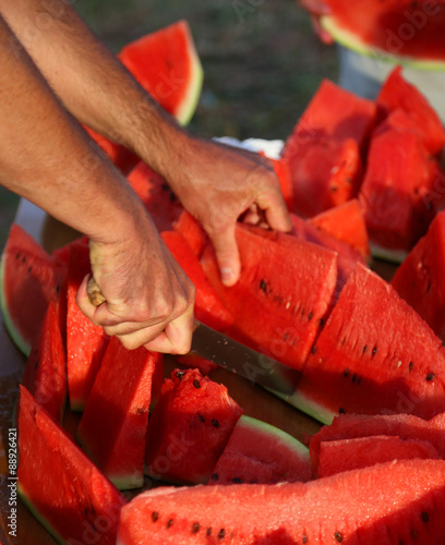 Cook cut thick slices of Ripe Red Watermelon on restaurant table