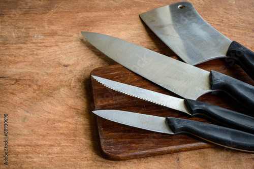 Set of kitchen knifes on wooden cutting board