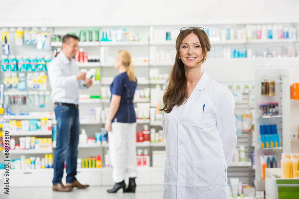Chemist Smiling While Assistant And Customer Standing In Backgro