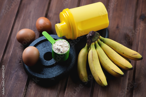 Shaker, scoop with protein, weight disks, eggs and bananas