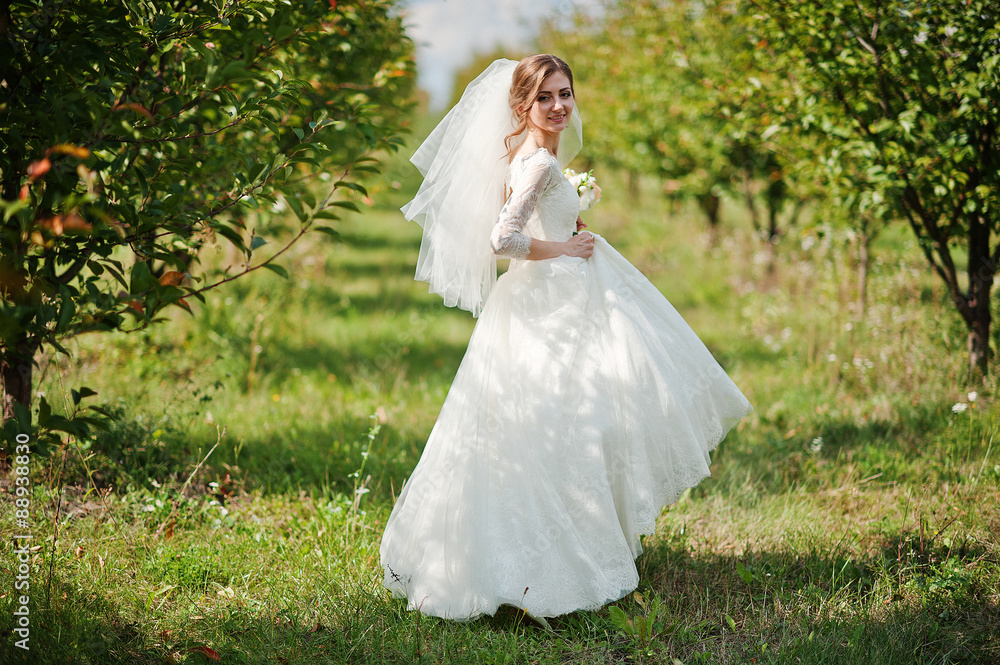 Gentle bride walking at apple garden