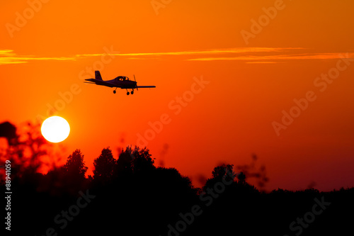 small airplane silhouette against the backdrop of the setting sun