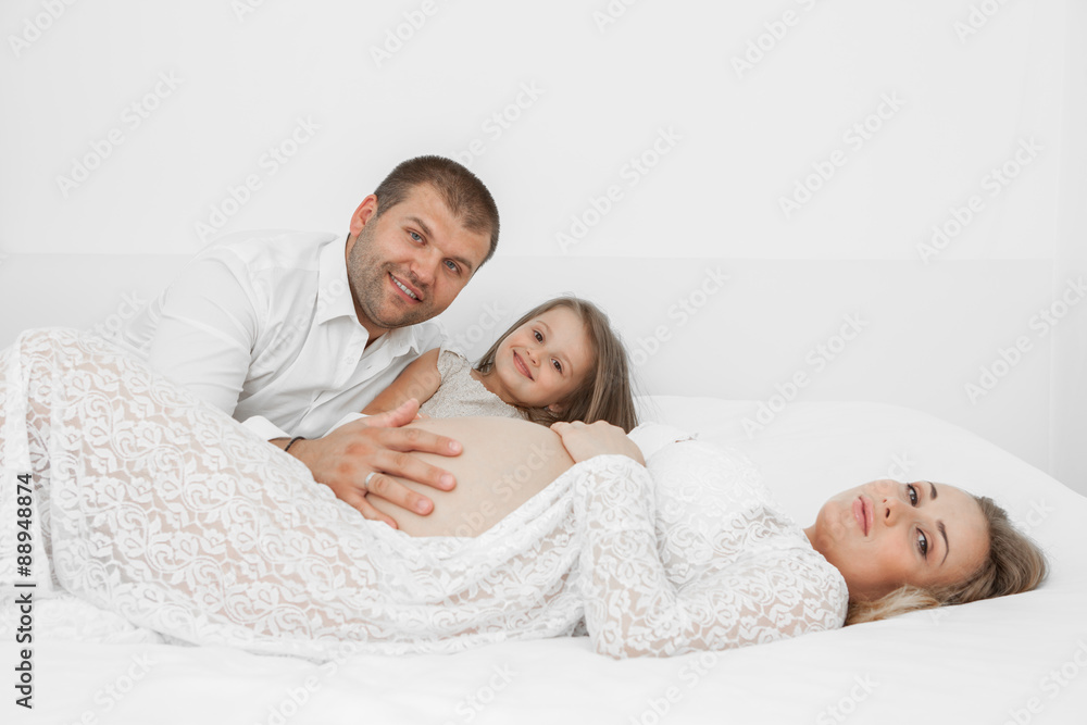 Pregnant lying on the bed with her husband Pregnant lying on the bed with her husband