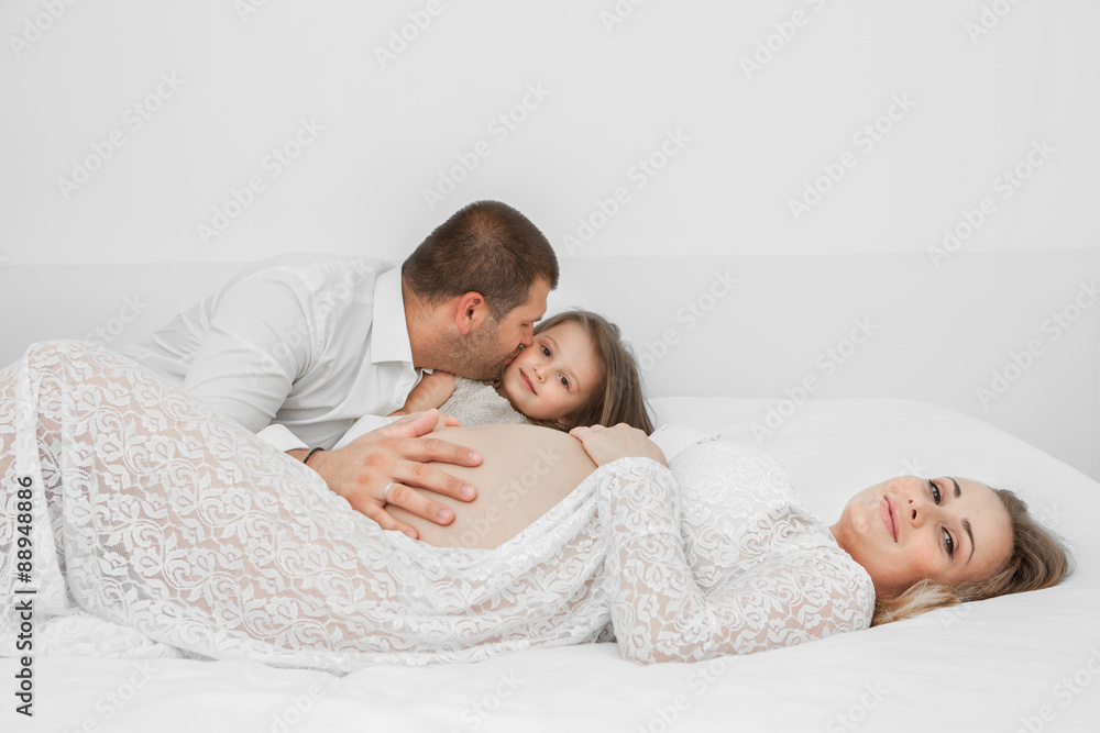 Pregnant lying on the bed with her husband Pregnant lying on the bed with her husband