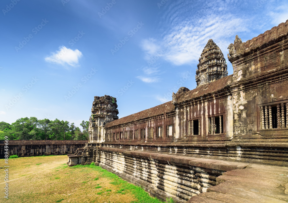 Wall of gallery and one of towers Angkor Wat temple, Cambodia