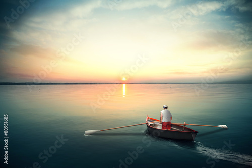 Sailor on a canoe rowing on the calm water