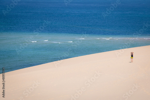 Girl walking on the white dunes on the beach of the Bazaruto Islands near Vilanculos in Mozambique with the Indian ocean in the background
 photo