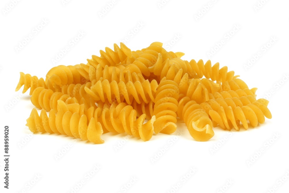 Pile of uncooked dry rotini pasta isolated on a white background Pile of uncooked dry rotini pasta isolated on a white background