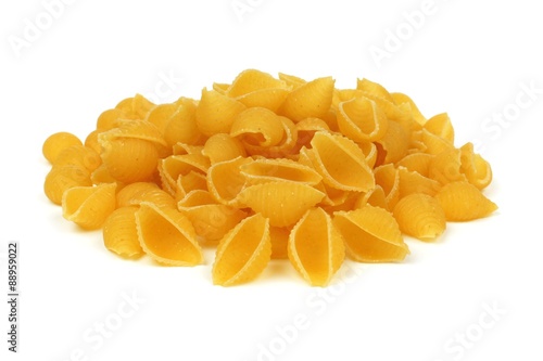 Pile of uncooked dry shell pasta isolated on a white background
