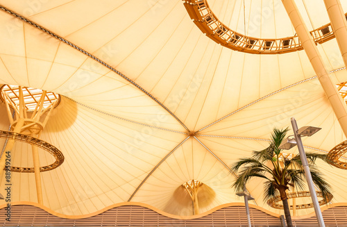 Big yellow canvas tent roof with palm tree in tropics