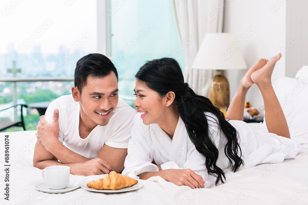 Asian couple having breakfast in bed