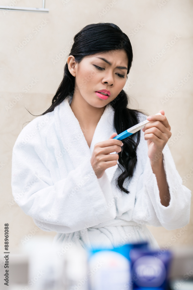 Asian woman being sad with pregnancy test Asian woman being sad with pregnancy test
