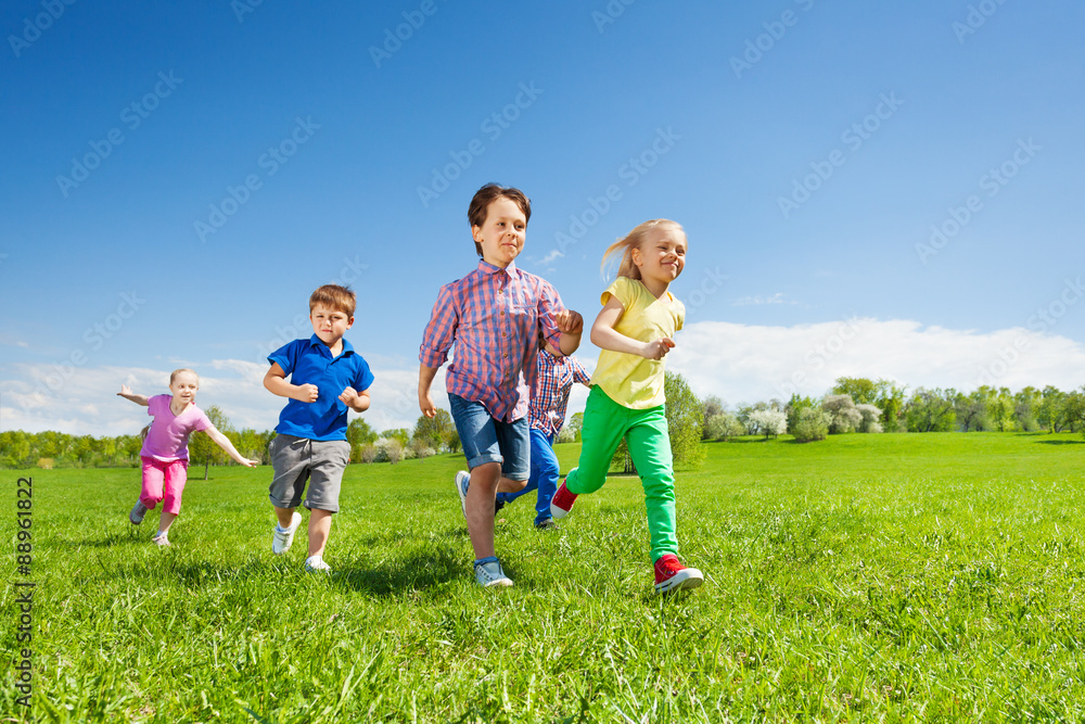 Happy group of children running in the green park Happy group of children running in the green park