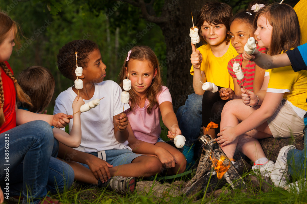 Group of children with s'mores near bonfire Group of children with s'mores near bonfire