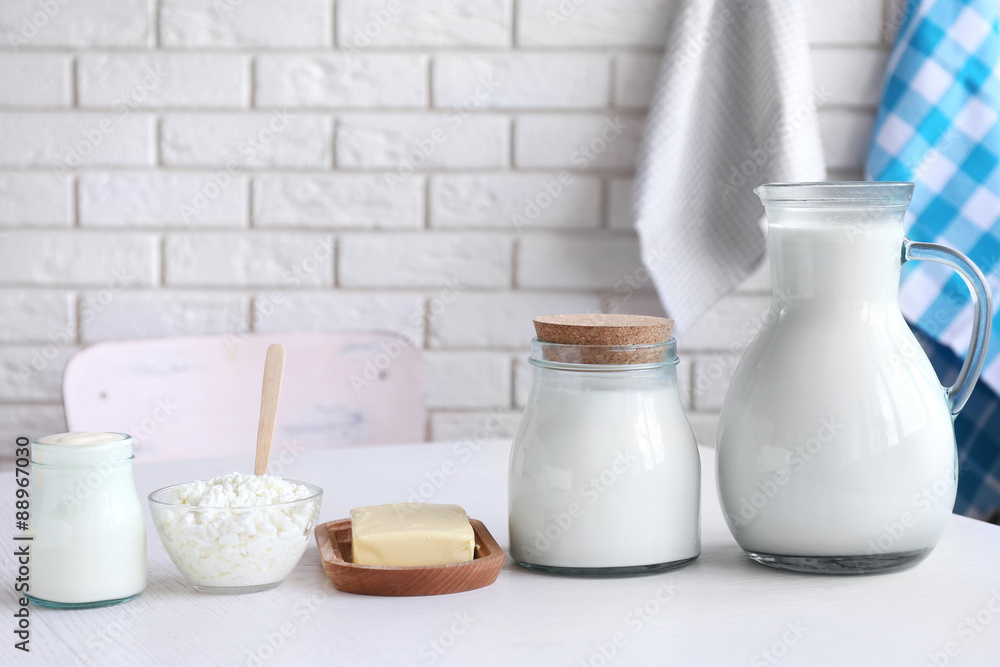 Dairy products on wooden table, on brick wall background Dairy products on wooden table, on brick wall background