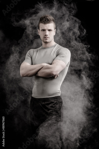 Portrait of handsome tough young man on dark background