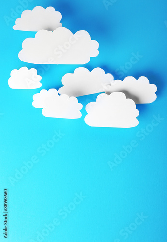 White paper clouds on blue background. Cloud computing concept.