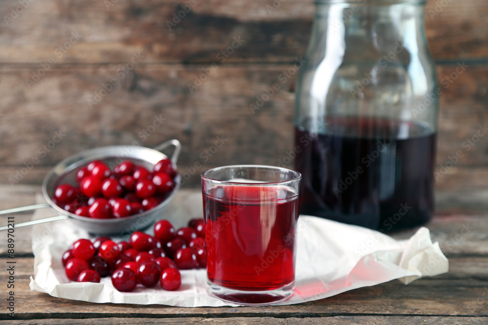 Glass with cherry juice on table, on wooden background Glass with cherry juice on table, on wooden background