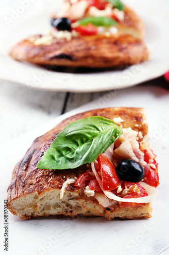 Pieces of homemade pizza on wooden board background