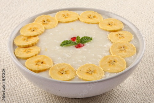 Organic rice pudding with cream and bananas. photo