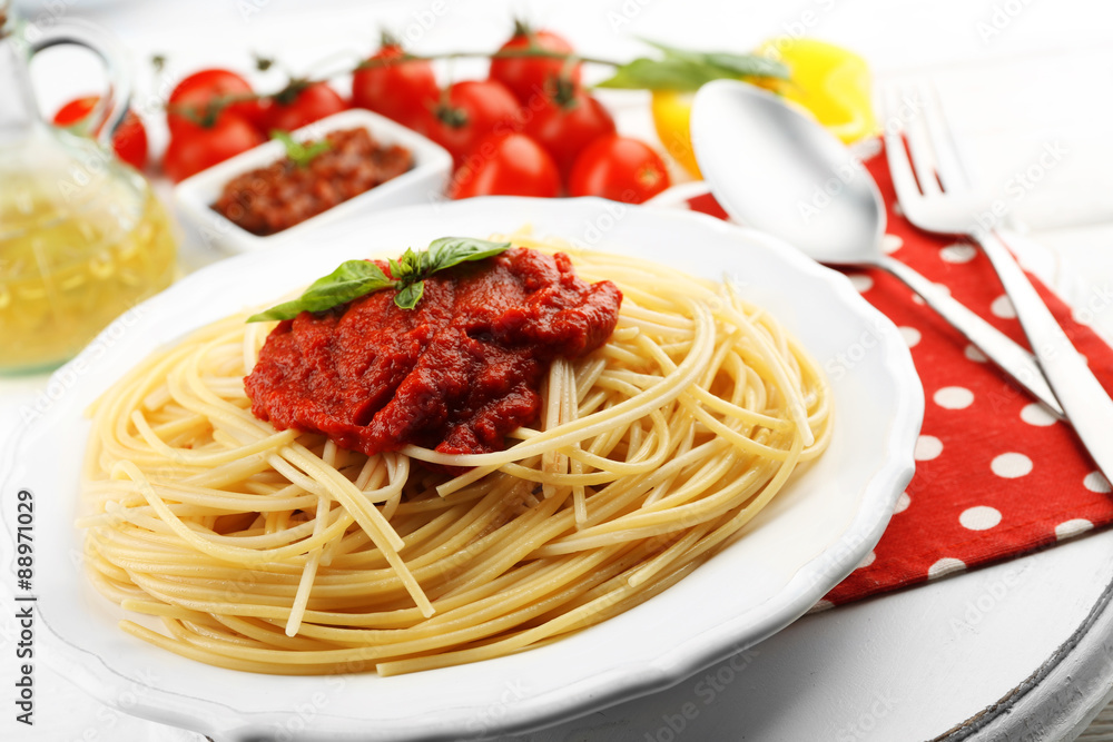 Spaghetti with tomato sauce and cheese on white plate, on color wooden background Spaghetti with tomato sauce and cheese on white plate, on color wooden background