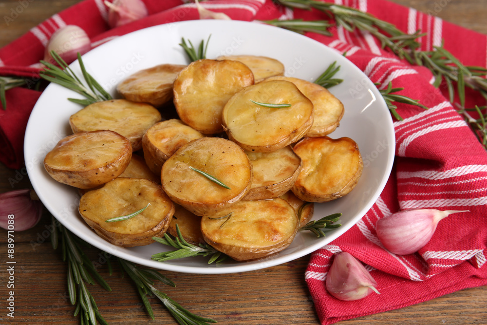 Delicious baked potato with rosemary in bowl on table close up Delicious baked potato with rosemary in bowl on table close up
