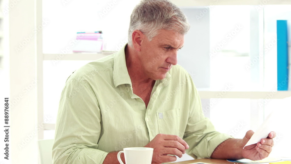 Casual businessman reading notes on paper Casual businessman reading notes on paper