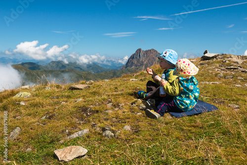two kids with sunhats resting during hiking in summer austrian alps with view © lukasx
