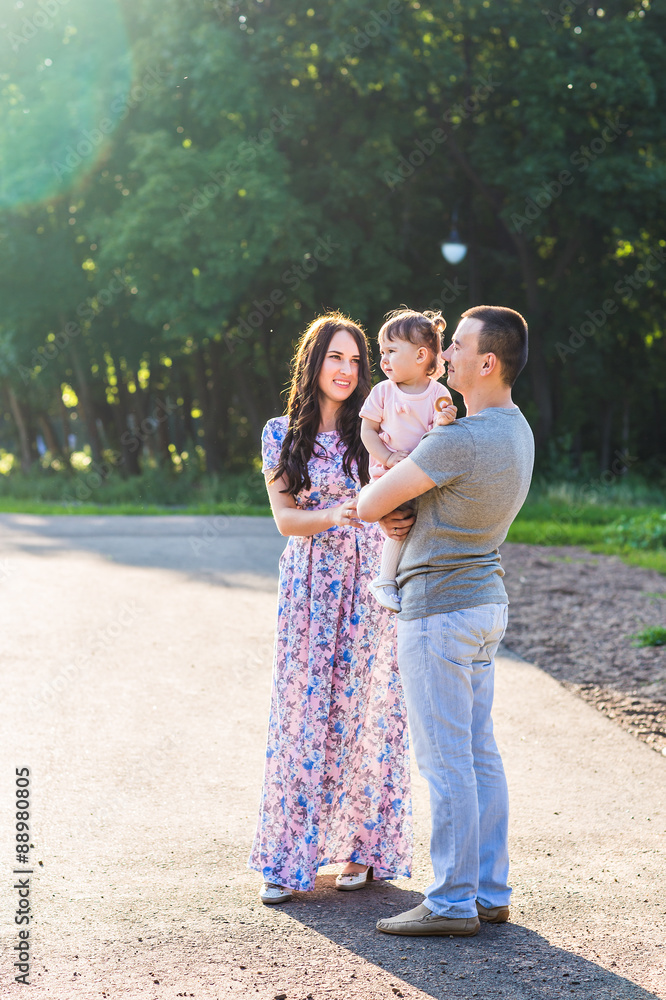 Happy Young Family Walking In The Park. Happy Young Family Walking In The Park.