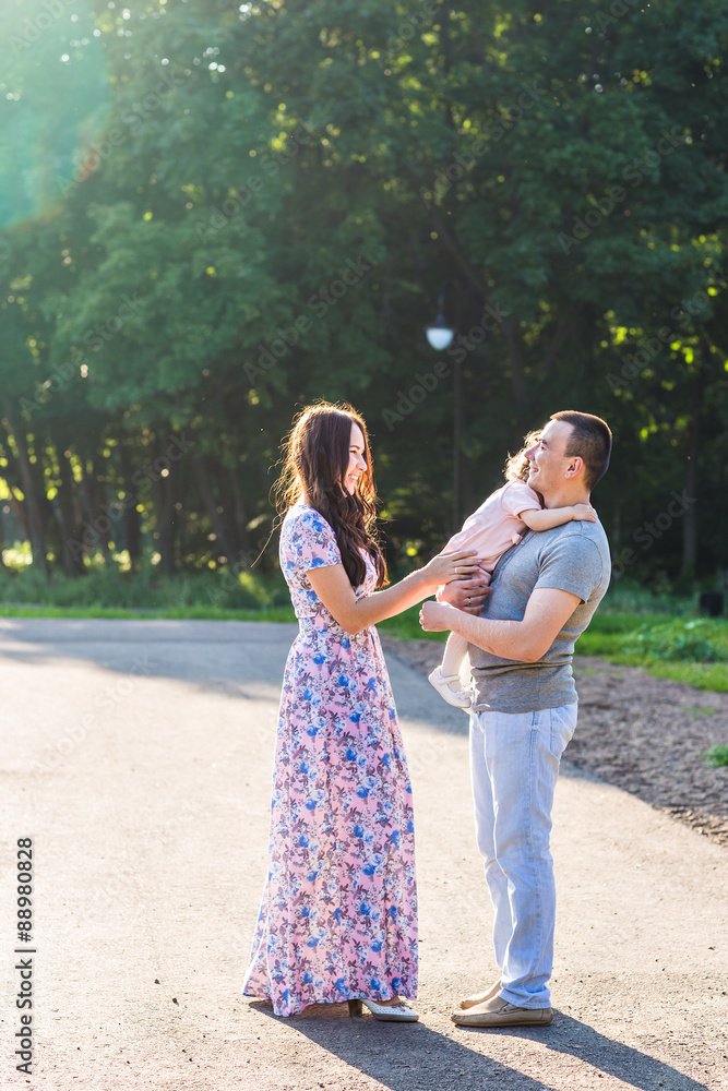 Fototapeta premium Happy Young Family Walking In The Park.