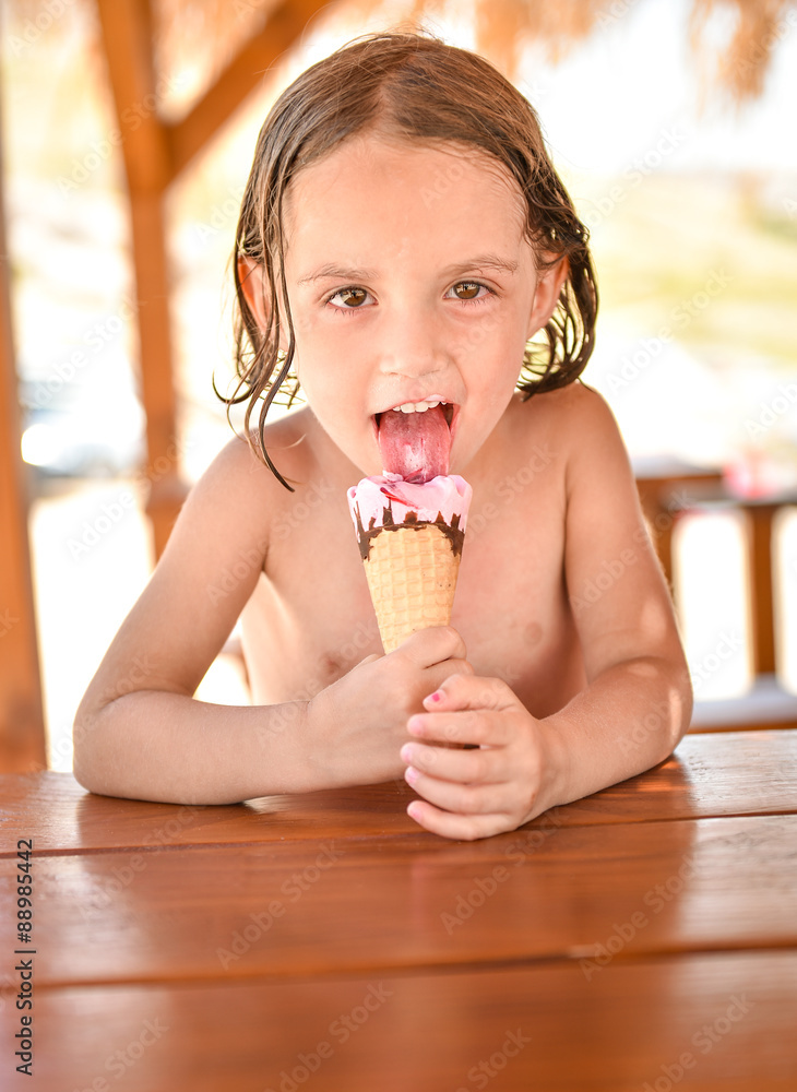 Little girl smiling and eating ice cream on vacation in a beach Stock Photo  | Adobe Stock