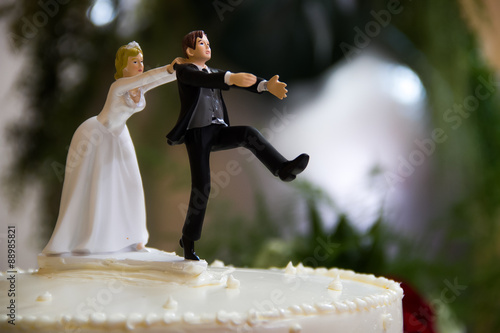 Cuadro en lienzo Bride catches groom wedding cake topper.