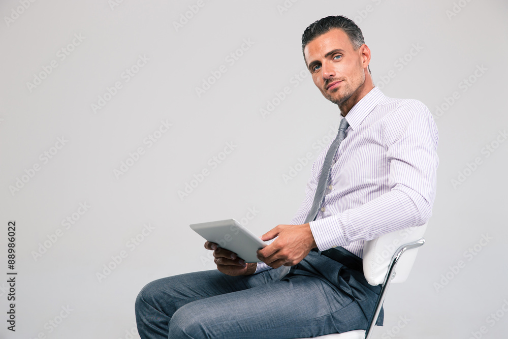 Businessman sitting on the office chair with tablet computer Businessman sitting on the office chair with tablet computer