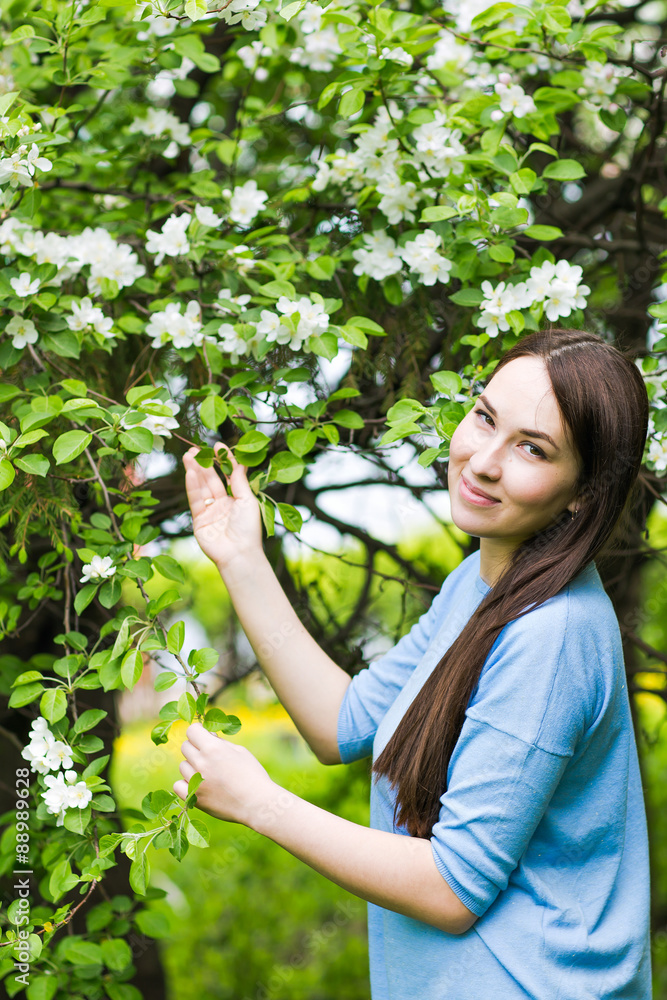 Portrait of spring brunette girl standing outdoor in blooming Portrait of spring brunette girl standing outdoor in blooming