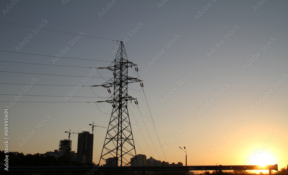 High voltage power line pylon over cloudy sky 