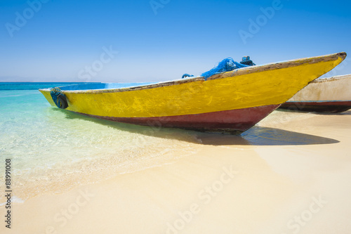 Traditional wooden boat on a tropical beach © Paul Vinten