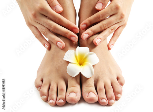 Fototapeta Naklejka Na Ścianę i Meble -  Female feet at spa pedicure procedure with plumeria isolated on white