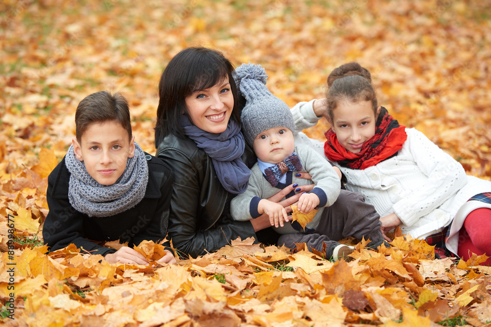 Fototapeta premium family in autumn park on yellow leaves