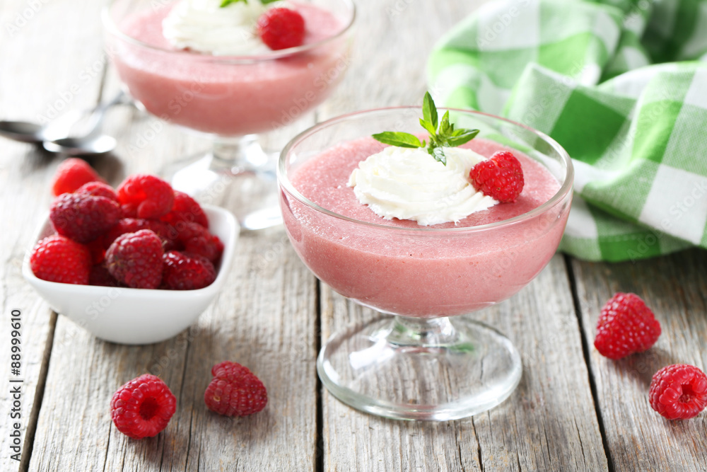 Sweet raspberry mousse in glass on grey wooden table Sweet raspberry mousse in glass on grey wooden table